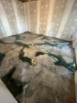 Concrete floor with Seagrass acid stain applied over and around the Miracle Gro granules, creating distinct color contrasts