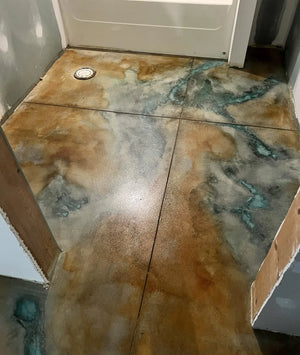 Bathroom concrete floor stained with Seagrass, Malayan Buff, and Miracle-Gro to create a marbled veining effect with green-blue and earthy tones