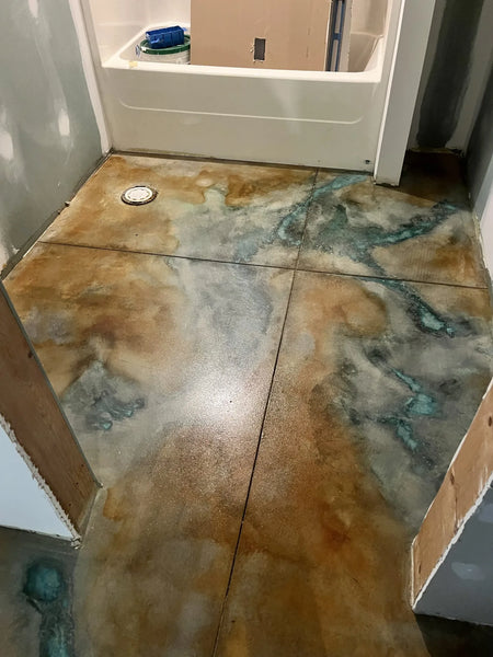 Bathroom with a concrete floor stained using Seagrass and Malayan Buff, creating a smooth, marbled effect