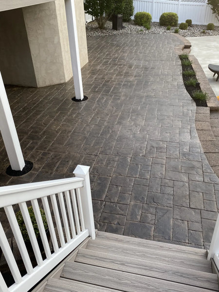 Multitoned charcoal stamped concrete floor with hints of brown undertones after application of stain