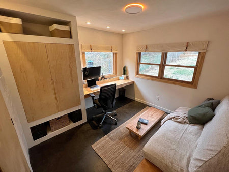 Fully furnished guest bedroom showcasing a beautifully dyed concrete floor