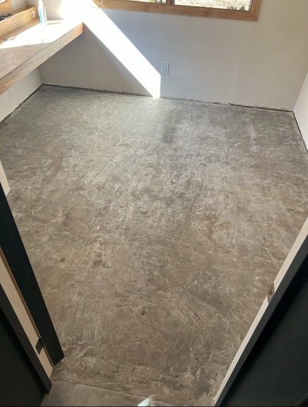 DIYer grinding the concrete floor with an angle grinder and diamond pad and filling cracks with a concrete patching compound