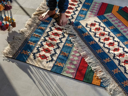 Two patterned rugs cover a concrete floor instead of placing carpet