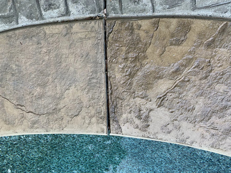 In-progress photo showing half of the pool coping with fresh Khaki stain and the other half in its original state