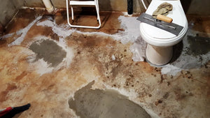 cracks in the bathroom's concrete floor are repaired with a gray concrete overlay