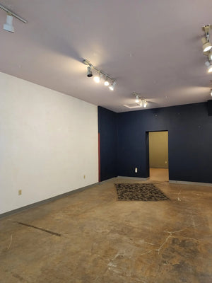 Before: Unfinished retail space concrete floor with unsightly stains, blotches, and glue residue