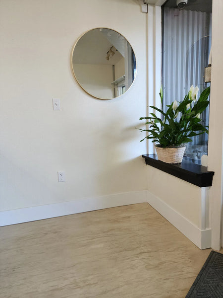 Photograph of the inviting entrance of a retail shop, highlighting the finished white concrete stained floor