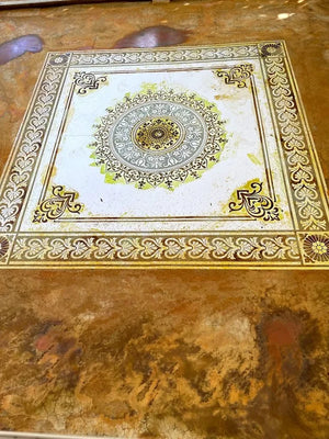 Stencil still on the floor with different colored acid stains applied over it