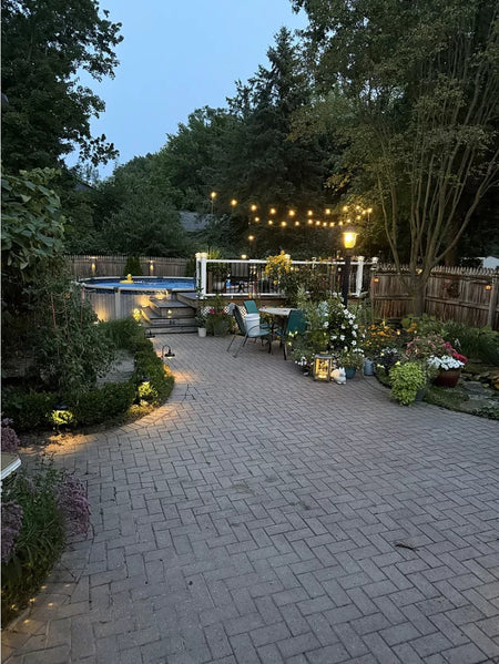 Revitalized brick courtyard stained with Aztec Brown and sealed with a satin finish, surrounded by vibrant landscaping