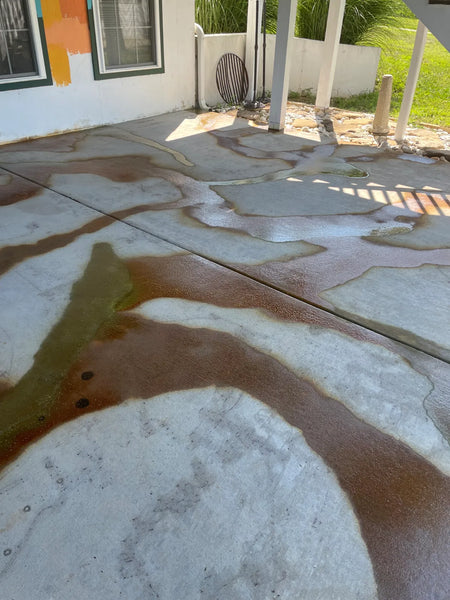 First spray of Coffee Brown and earth-tone EverStain acid stain reacting on a bare broom-finish concrete patio