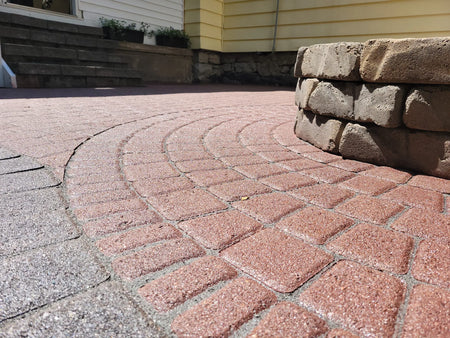 Close-up view of the patio pavers showcasing the rich texture and color of Cinnabar tint and grey polymeric sand