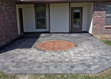 A circular paver design on a charcoal Portico stained patio with an inner circle stained in terracotta