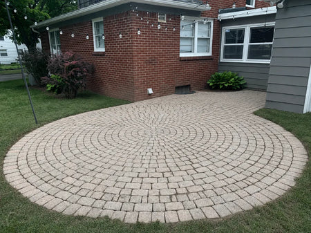 Dated pink concrete paver patio in a circular cobblestone pattern before whitewashing with PaveWave White