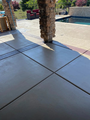 painted concrete Patio surrounding a swimming pool before stripping and EasyTint resurfacing