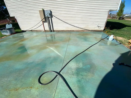 Azure Blue acid stain being applied to a new concrete patio with a sprayer for a turquoise finish