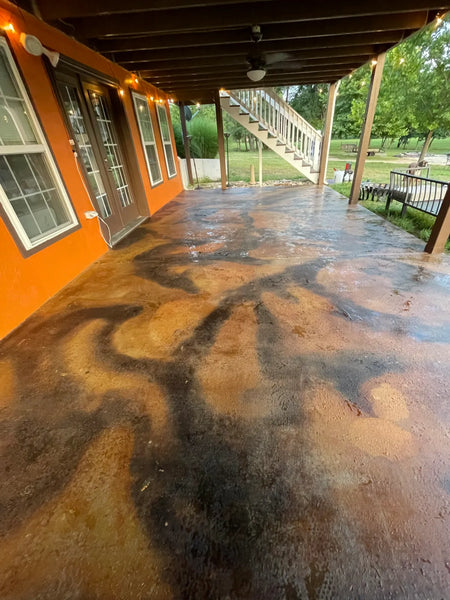 Finished covered concrete patio acid stained in mottled Coffee Brown and earth tones, sealed with EasySeal Gloss for a wet-look shine, lit with string lights
