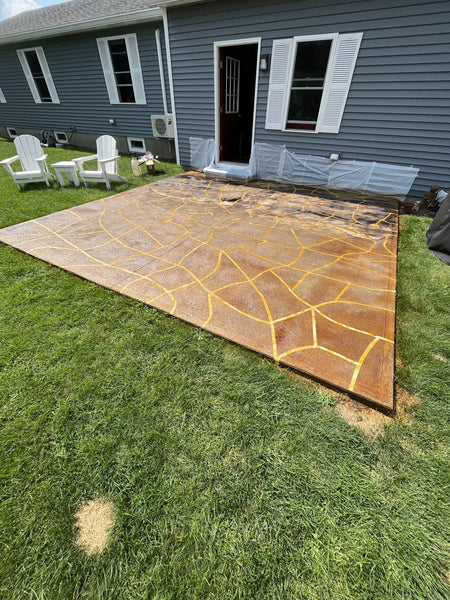 The taped concrete patio floor immediately after being sprayed with Blackish EverStain acid stain