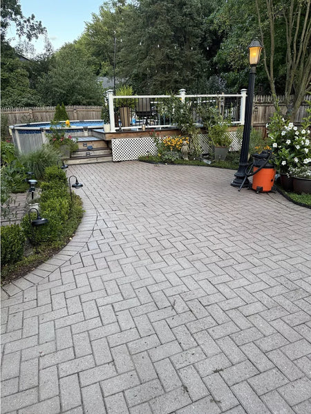 Before photo of faded brick courtyard with light-colored pavers showing signs of aging and wear