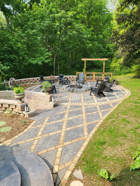Fully transformed patio with light charcoal stained concrete diamonds, complemented by moss-inspired garden stepping stones