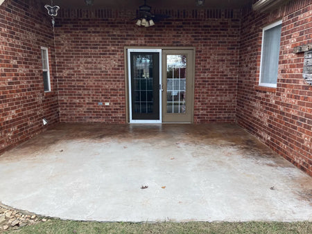 Smooth concrete patio with faded color and uneven discoloration before restoration