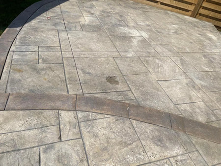 Faded two-tone stamped concrete patio before applying Aztec Brown and Khaki Antiquing Stain