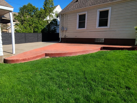 Faded red stamped concrete patio before restoration with Black and Charcoal Antiquing Stain