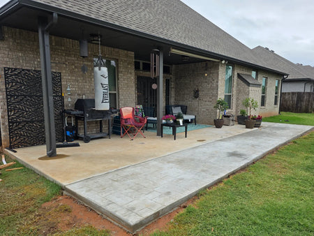 Before: a dull, newly extended patio — smooth original slab plus a stamped extension — awaiting its transformation