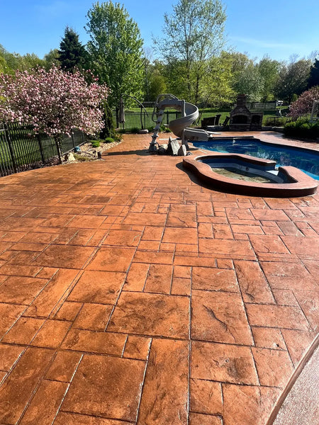 Warm golden-brown stamped concrete pool deck and raised spa finished with Yukon Gold EasyTint satin