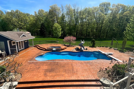 Elevated wide view of a large stamped concrete pool deck restored with warm Yukon Gold