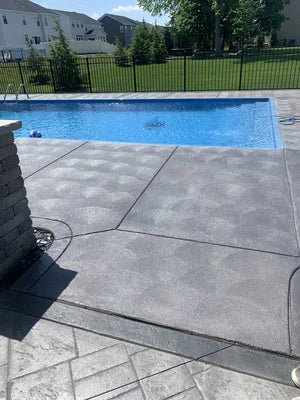 Gray EasyTint Satin on a swirl-finish concrete patio beside a bright blue backyard swimming pool