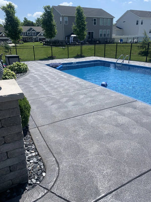 Finished gray swirl-finish concrete pool deck surrounding a backyard swimming pool after EasyTint Satin application