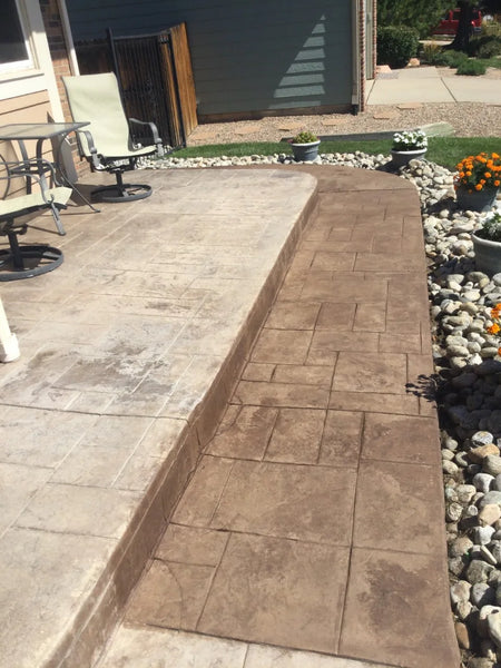 First coat of driftwood Antiquing™ stain on faded stamped concrete patio
