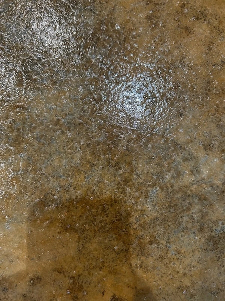 Sealer cracking and lifting over leftover acid stain residue on a concrete floor