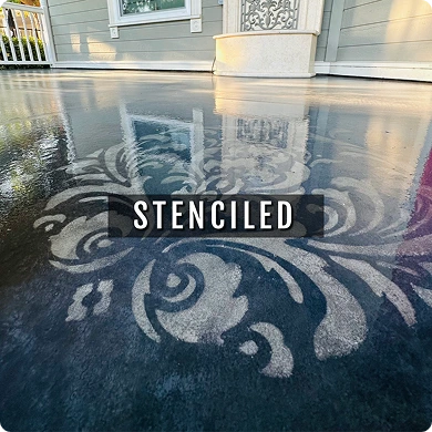 Decorative stenciled design on a concrete surface with a house in the background