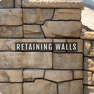 Stone wall with 'Retaining Walls' sign