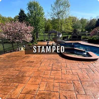 Stamped concrete patio with pool and garden in the background