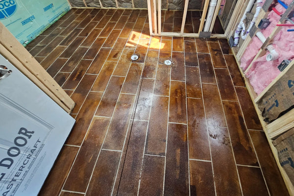 Finished concrete bathroom floor stained to look like Coffee Brown wood planks, neutralized and sealed
