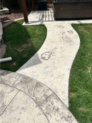 Faded, discolored stamped concrete patio and walkway before staining