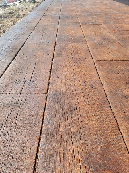 Sealed wood-plank stamped concrete patio in Coffee Brown EverStain acid stain with a rich wood finish