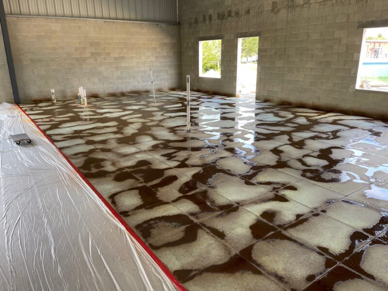 Photo of a concrete floor showcasing the striking effect of the Black acid stain veining technique applied as an accent color over the Azure Blue base.