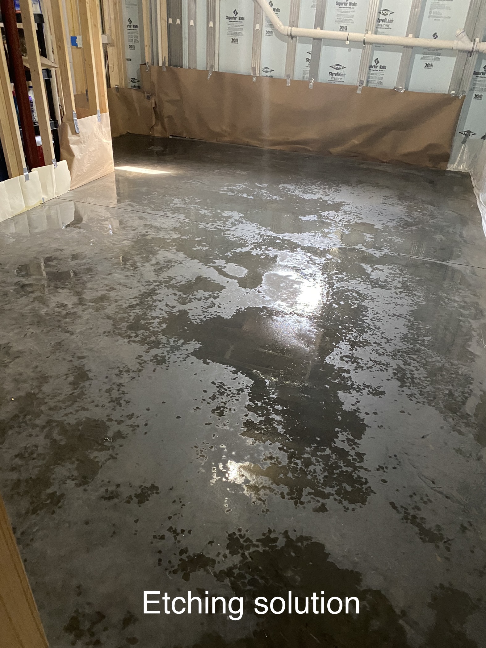 Applying CitrusEtch solution to a concrete floor to prep for acid stain