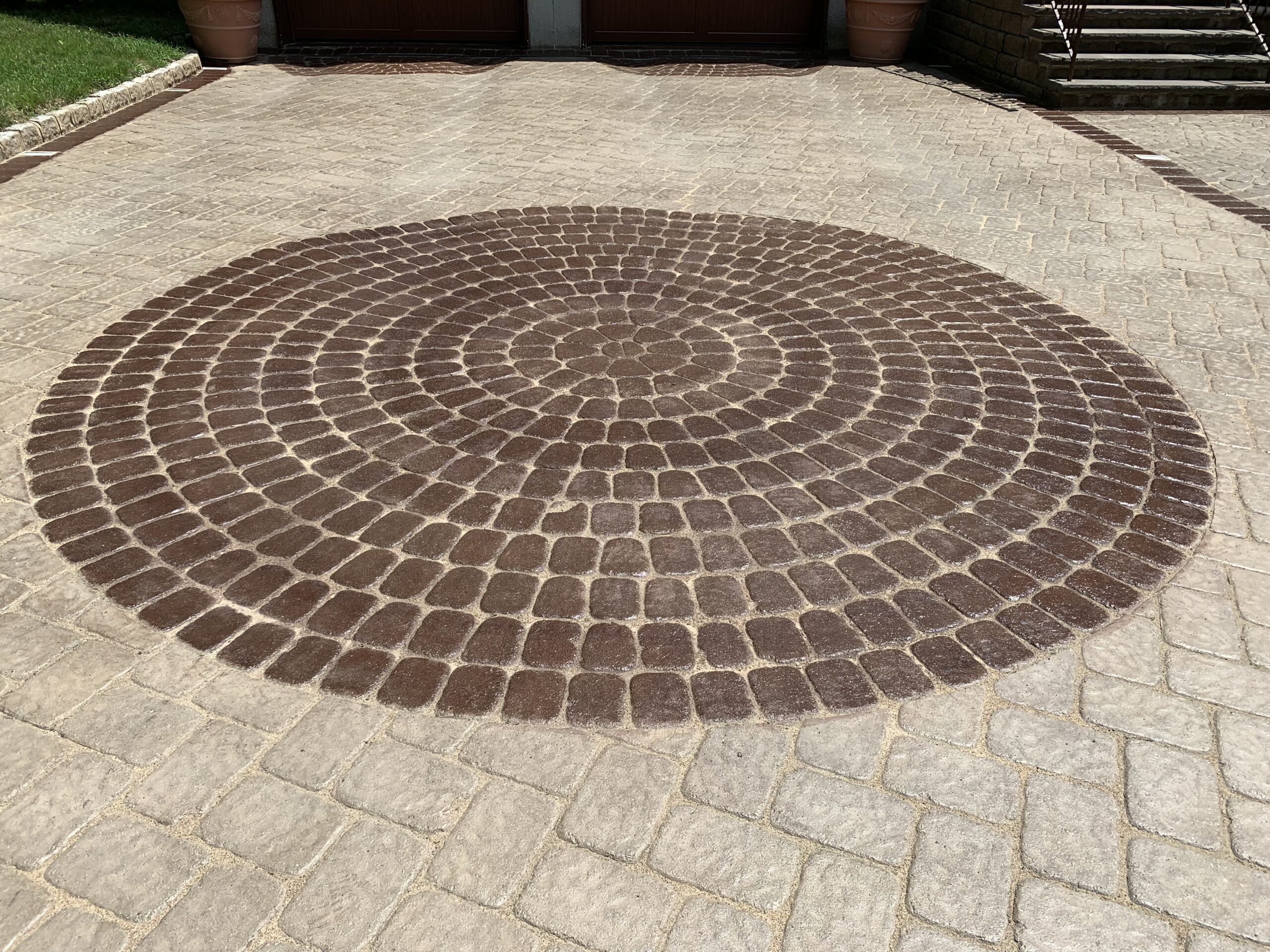 Bringing a touch of elegance to your driveway with a bold Aztec brown Portico stained paver circle design.
