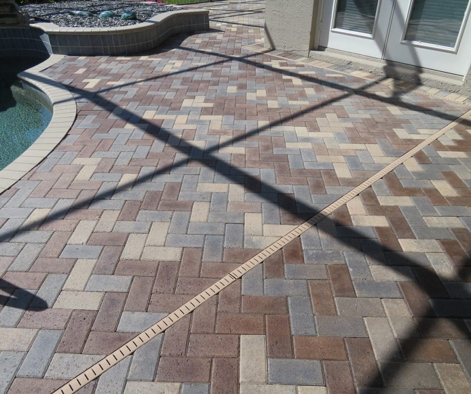 Fully sealed and finished pool deck pavers, gleaming under the sunlight, showing off their revived colors