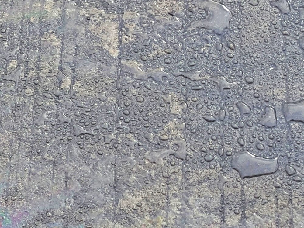 Water beading on a sealed concrete surface.