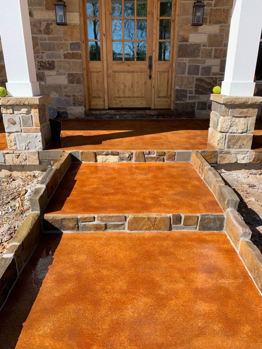 The completed front porch steps of an estate home, displaying the warm, rich tones of Cola EverStain