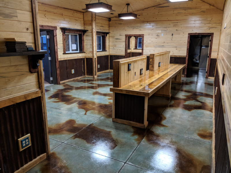 A barndominium office space with a concrete floor stained in a marbled pattern using azure blue and coffee brown acid stains