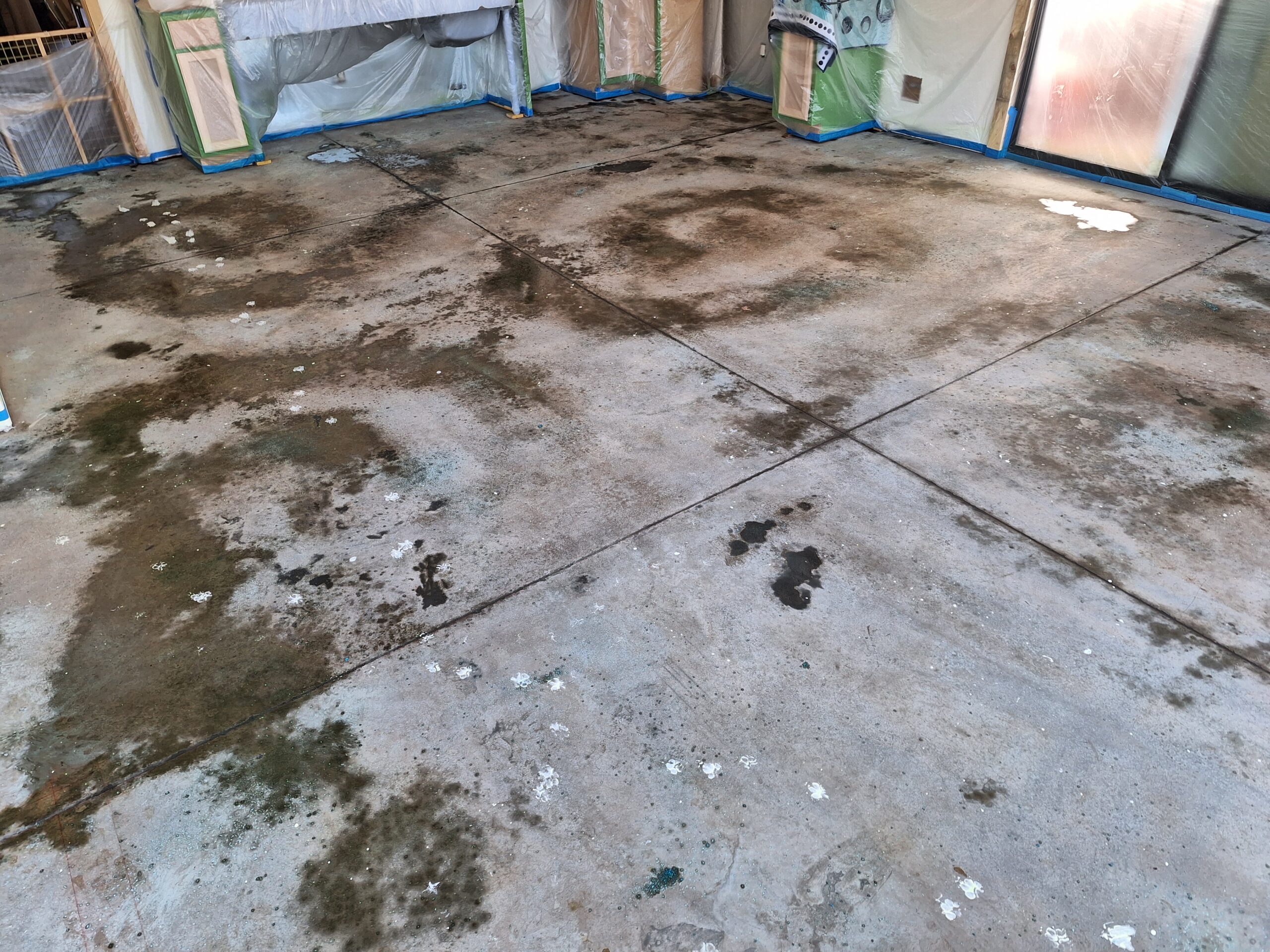 Image of a large metal building interior showing a bare, distressed concrete slab floor.