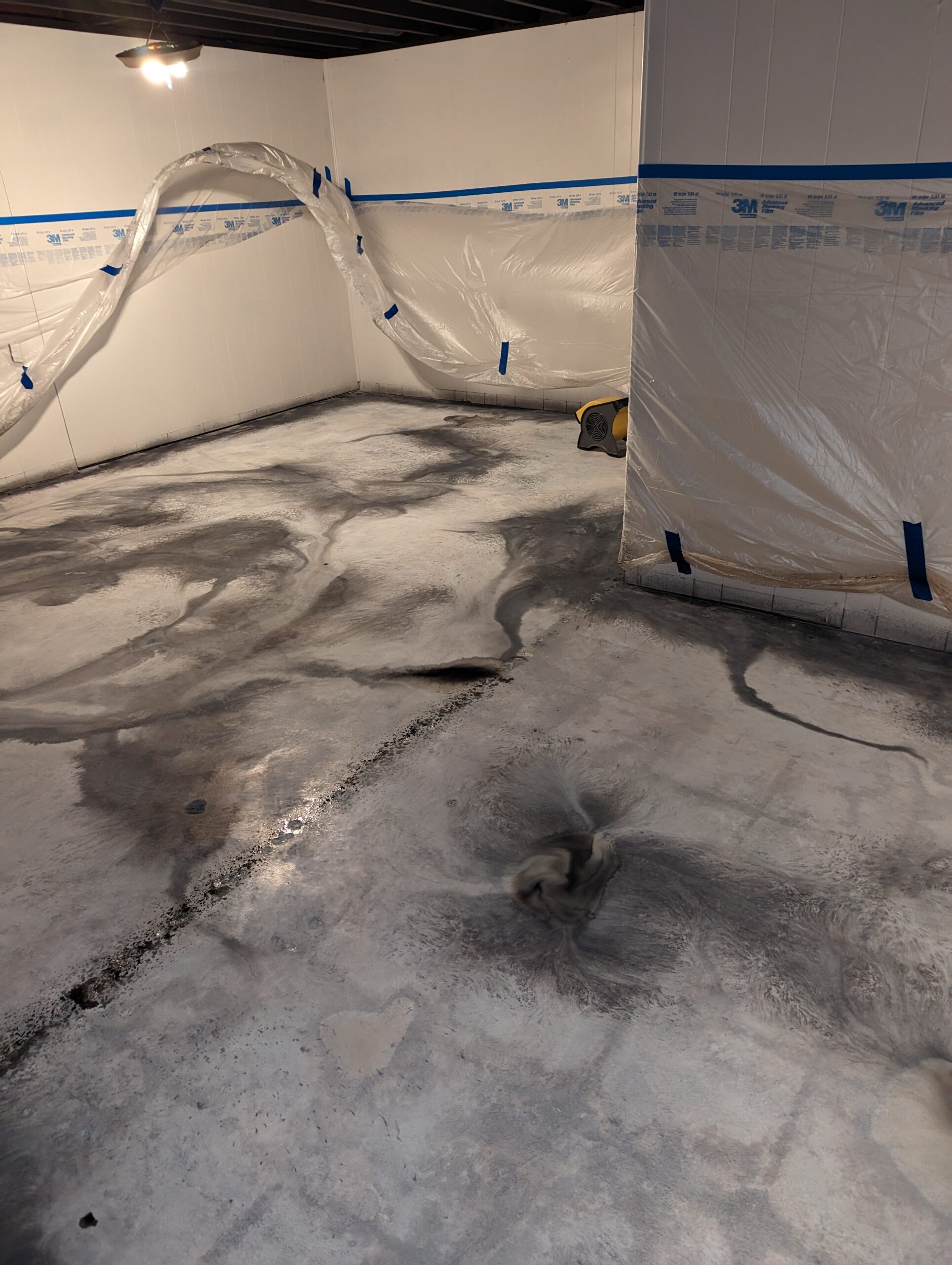 Image showcasing the basement floor after applying white and Steel Gray ColorWave stains, creating a marble-like veining design