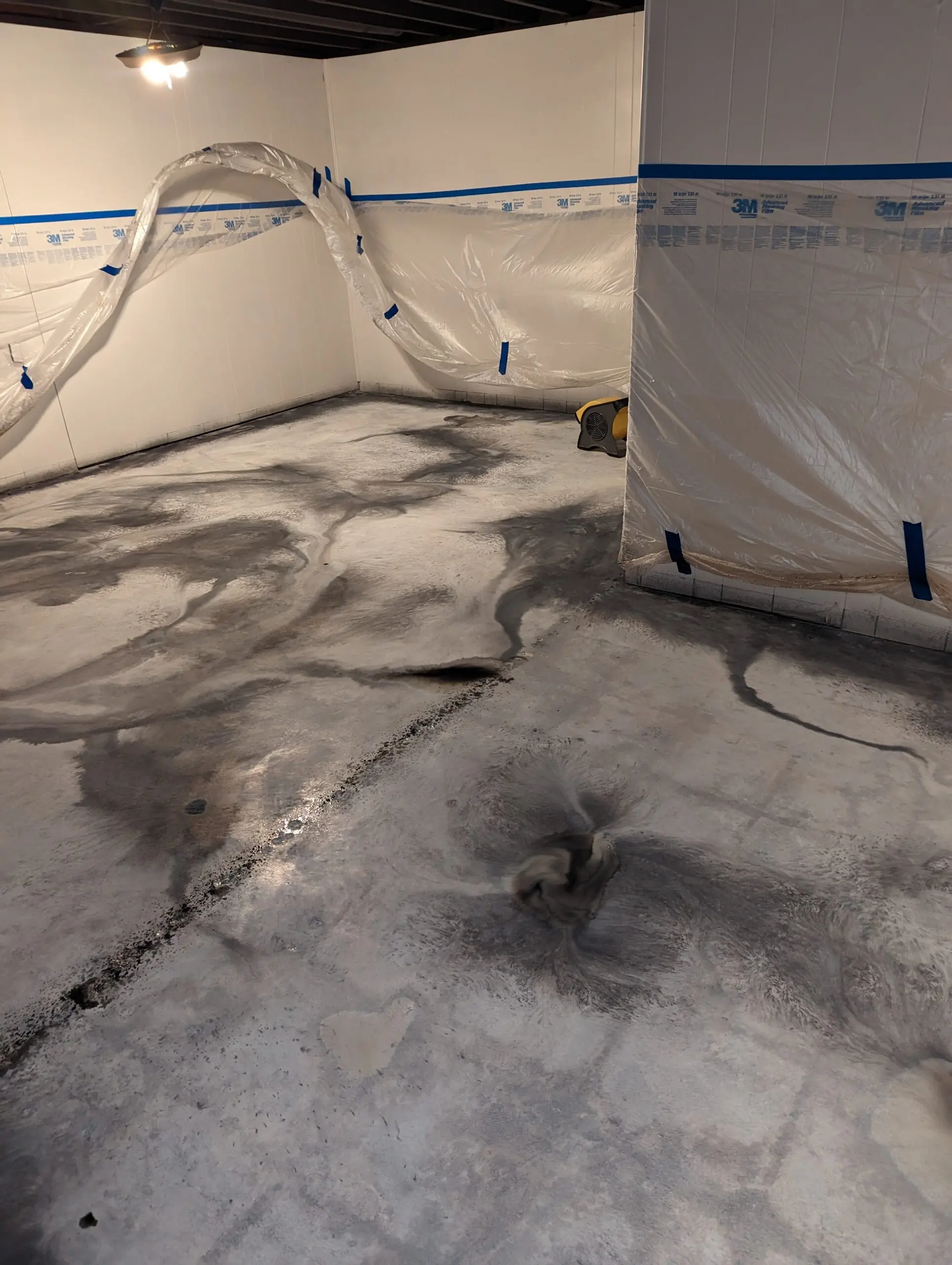 Image showcasing the basement floor after applying white and Steel Gray ColorWave stains, creating a marble-like veining design