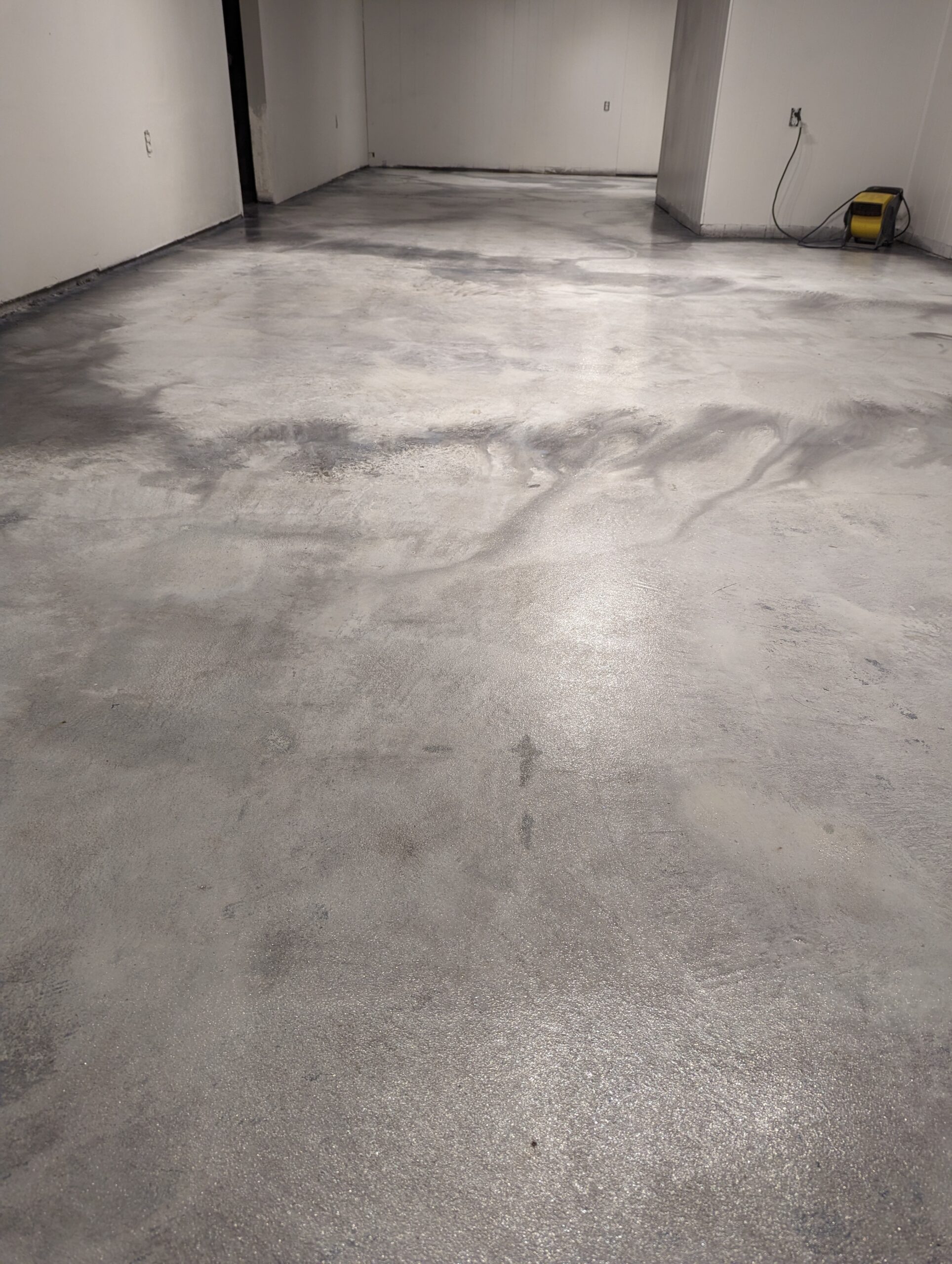 Image highlighting the basement floor after the first coat of sealer has been applied